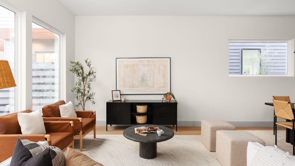 Living room seating facing a black console and abstract artwork