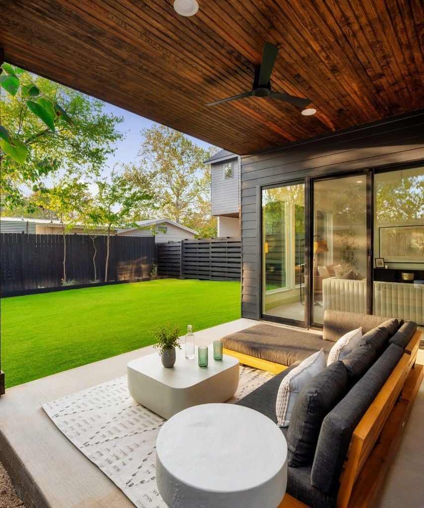 Covered patio with wood plank ceiling and outdoor sectional overlooking the yard